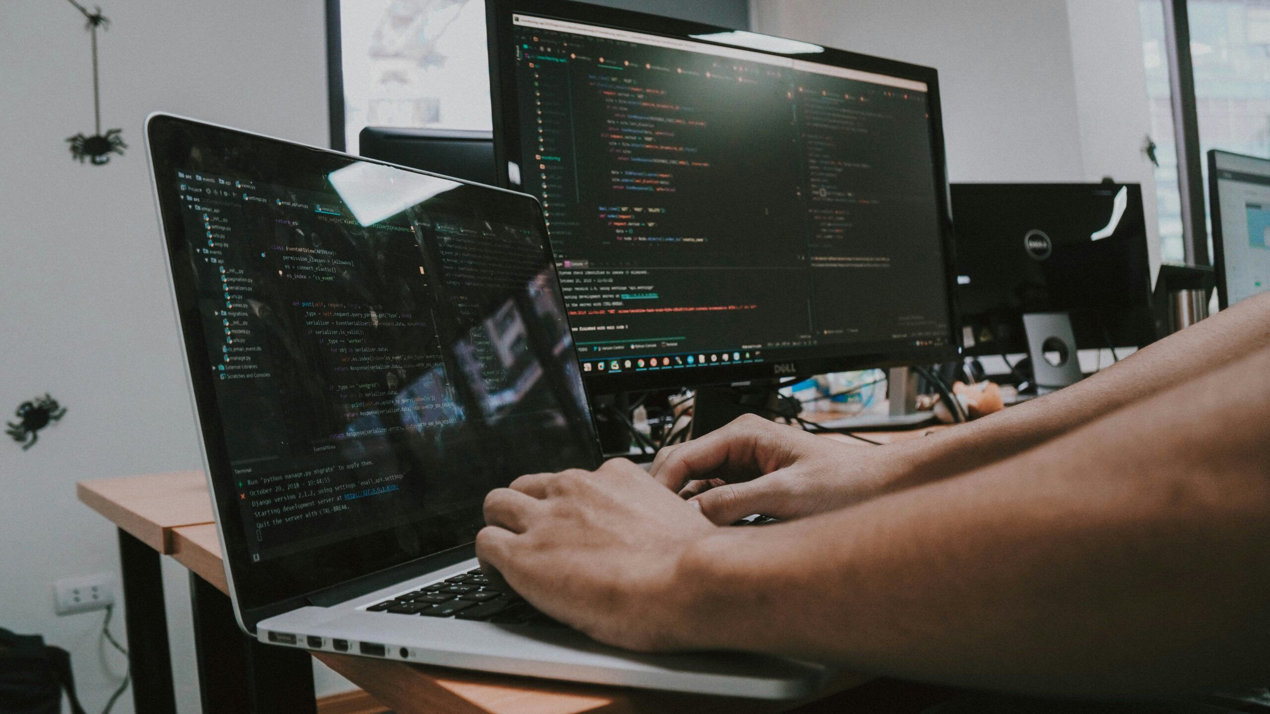 Person working at a laptop computer, coding a cloud solution.